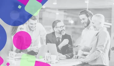 Équipe diversifiée en réunion professionnelle, discutant autour d’un ordinateur, symbolisant la collaboration entre France Travail et Talents Handicap pour faciliter le recrutement des personnes en situation de handicap